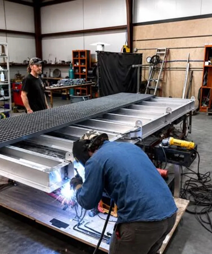 S&F Fabrication team welding a metal frame in the workshop